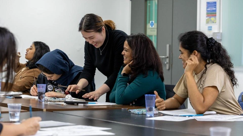 A group of students at a table doing crafts.