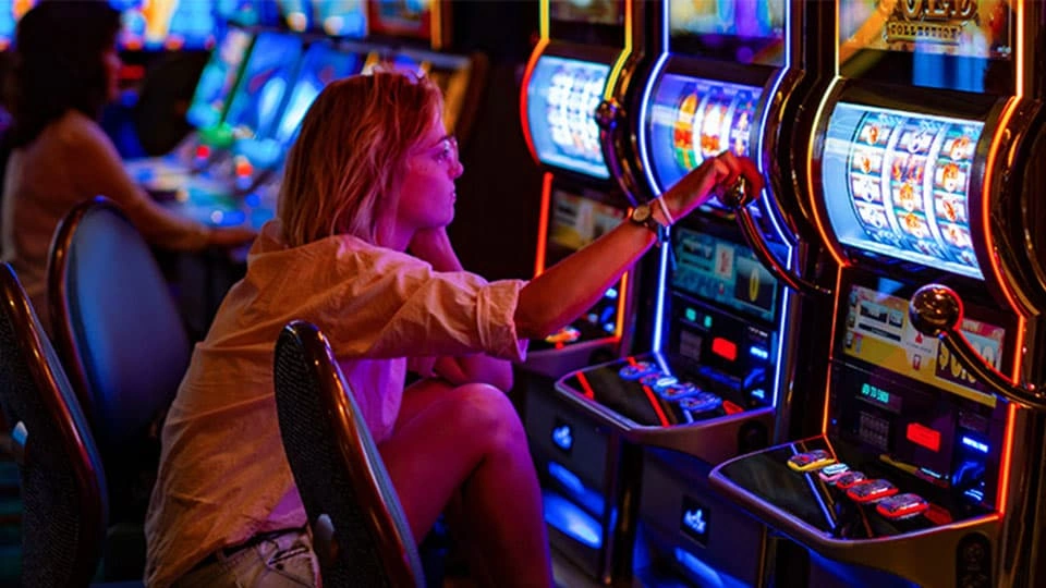Woman playing brightly coloured casino machines