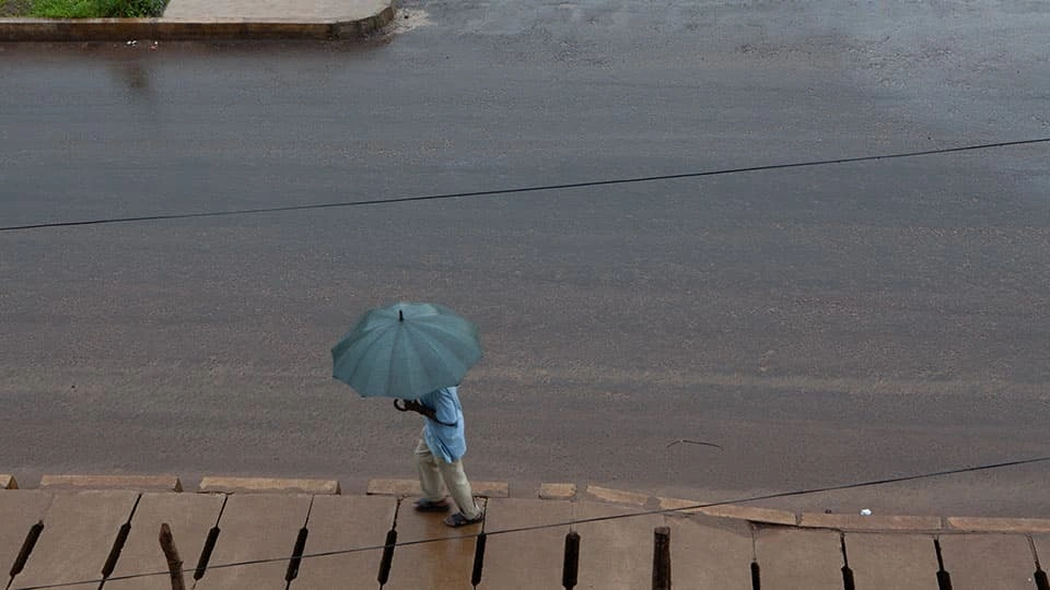 Man walks through flooded street with an umbrella