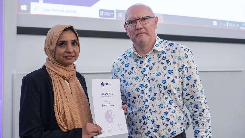 Samia Qamar holding a certificate and standing with Professor Steve Christie.