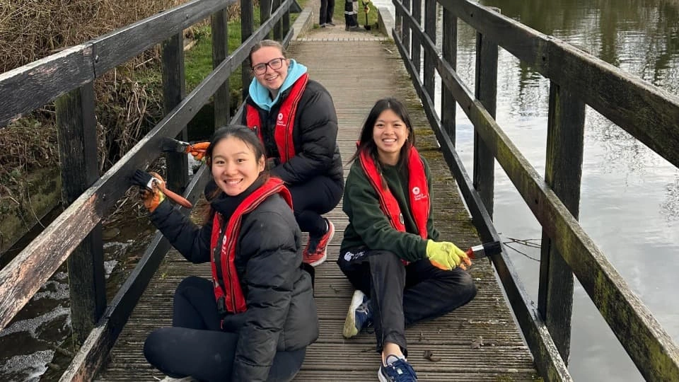 Students cleaning the canal and smiling