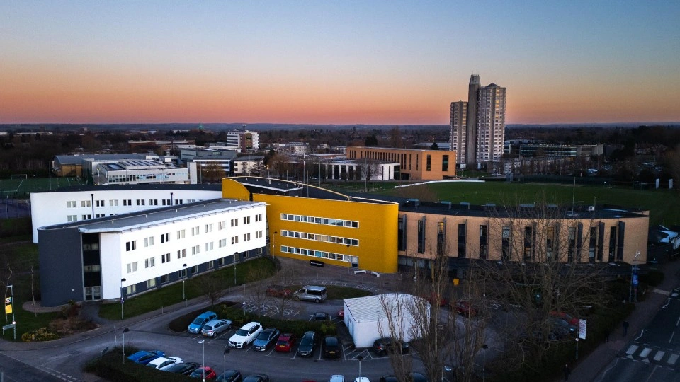 An aerial view of Loughborough Business School with a pretty red sunset.