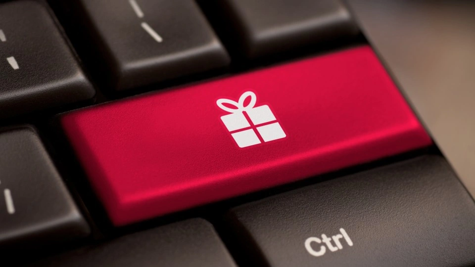 Close-up of a computer keyboard with a bright red key featuring a white gift box icon, located next to the black Ctrl key.