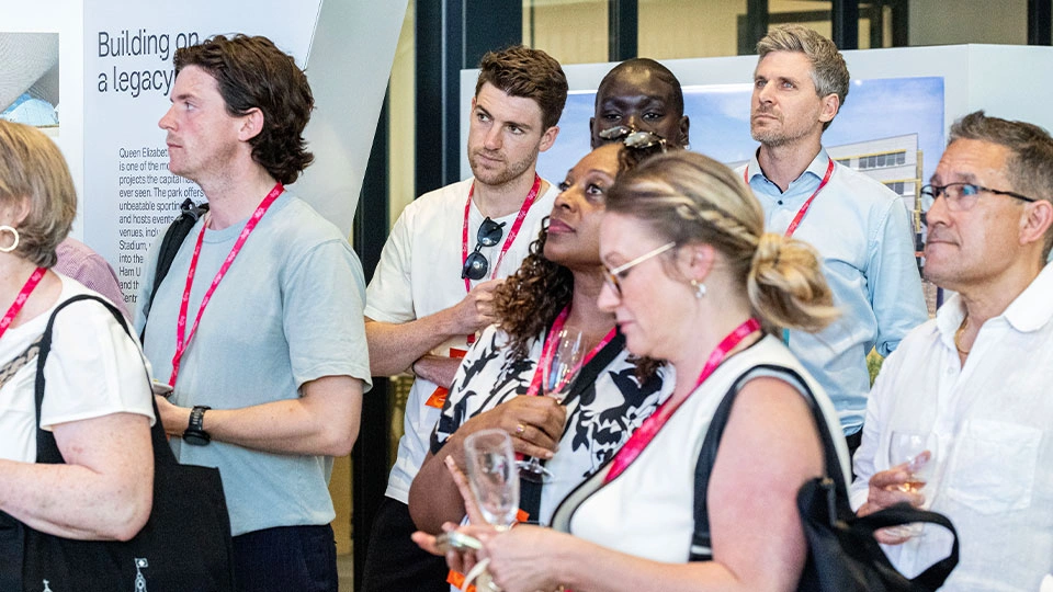 Show visitors watching a talk wearing lanyards
