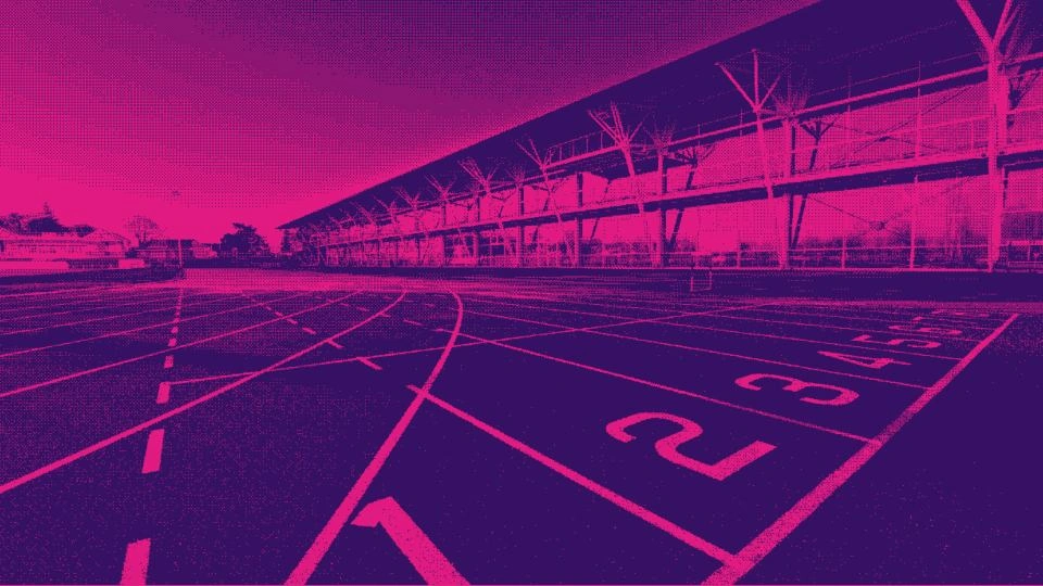 Photo of an outdoor running track with a pink and purple filter on.