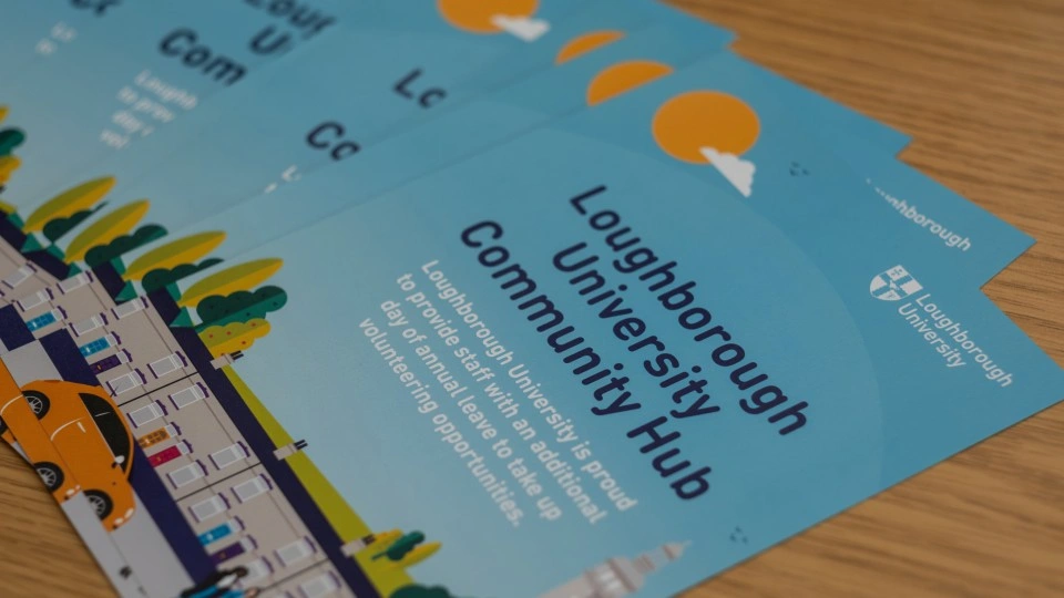 Leaflets spread across a table with the title 'Loughborough University Community Hub'