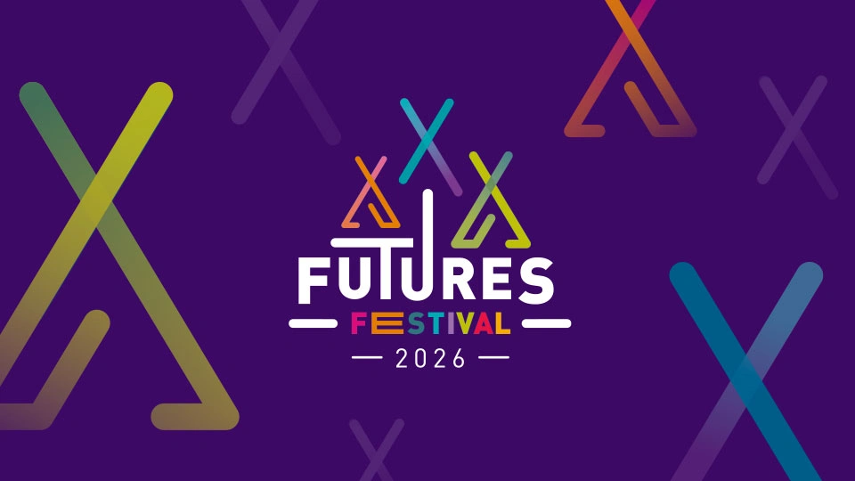A purple background featuring colorful abstract shapes resembling teepees in gradient hues of green, blue, orange, and pink. At the center, bold white text reads 'FUTURES'. Below, smaller text in rainbow colors says 'FESTIVAL' and underneath that, white text reads '2026'.