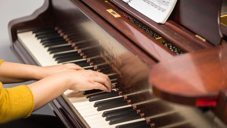 Close-up of a person's hands playing a piano.