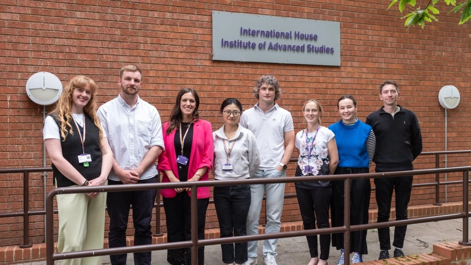 A group of people posing in front of the International House