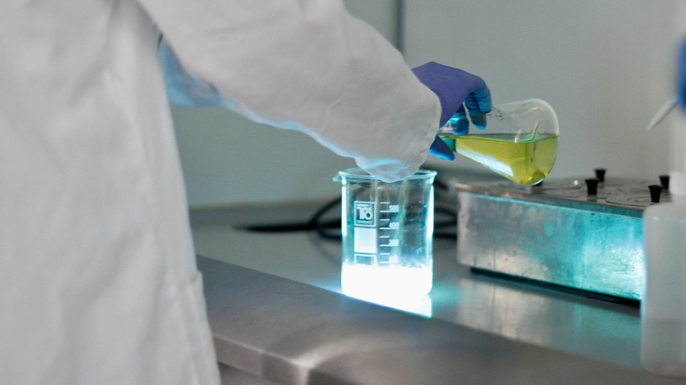 Student creating a glowing solution in a lab