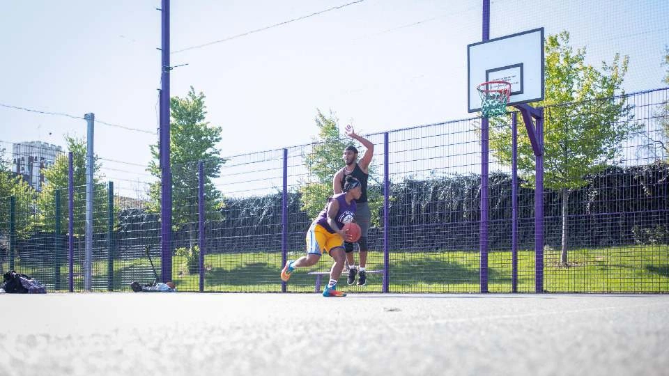 two people playing basketball on an outside court