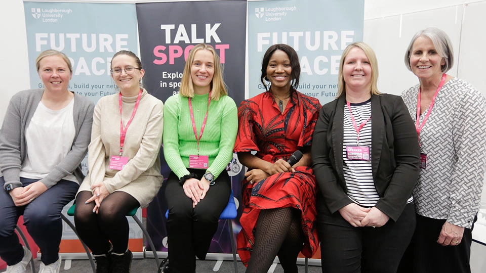 Six people sat on chairs, smiling at the camera