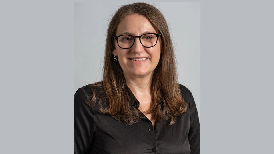 Close-up of Tanja Radu in front of a grey background.