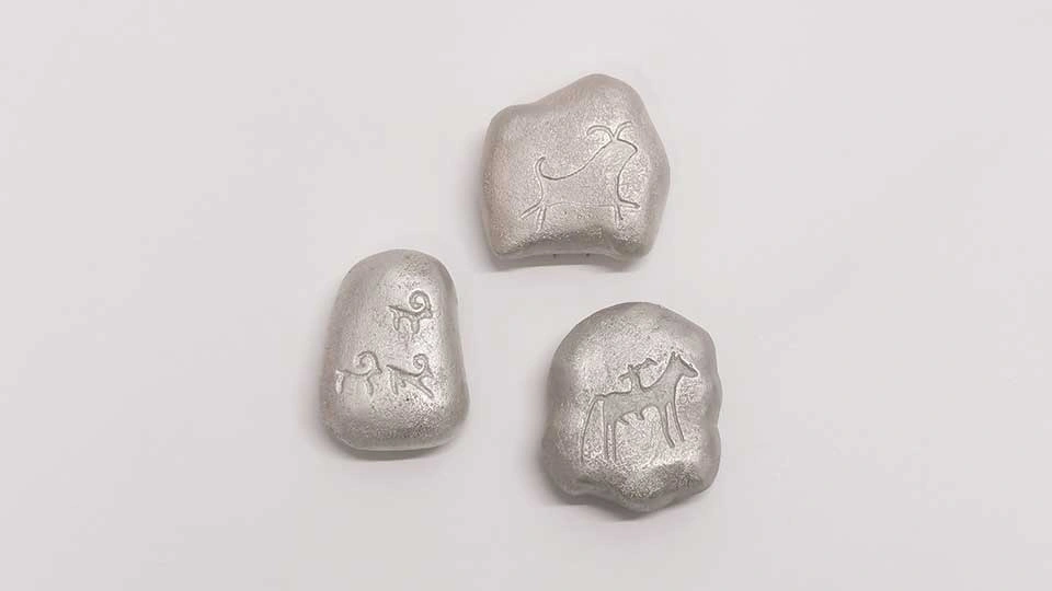 Three silver brooches engraved with symbols of animals.