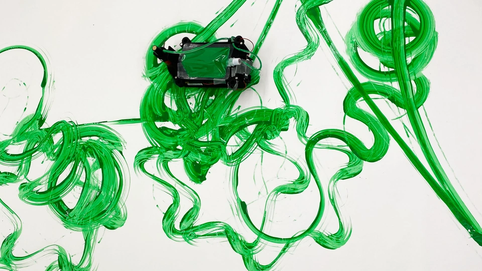 Robot painting green paint on a white canvas