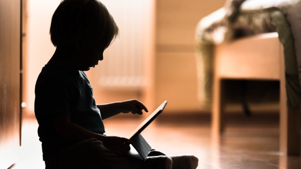 A baby sat with a tablet