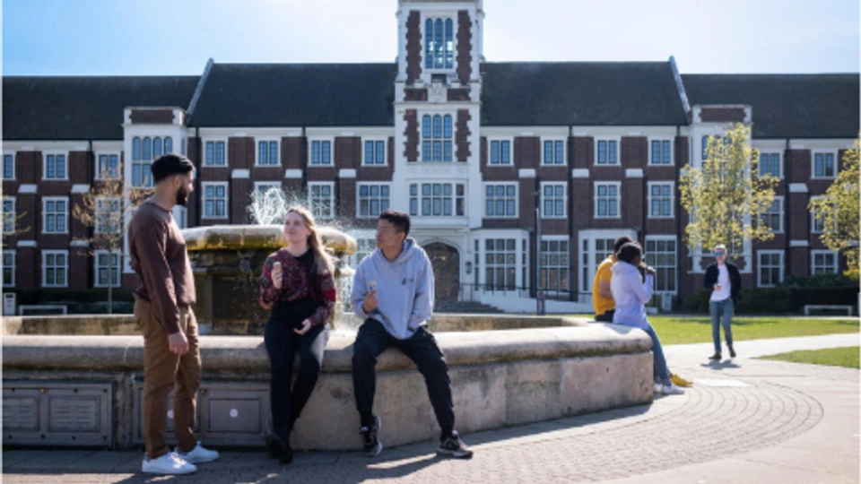 Three students sitting at fountain