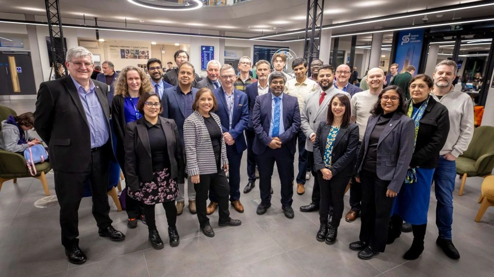 A group of academics are gathered in a science lab celebrating the award shortlist