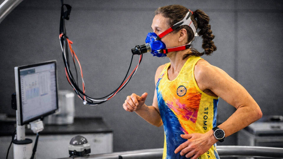 A woman is running on a treadmill with a face mask on taking part in some sports-related research