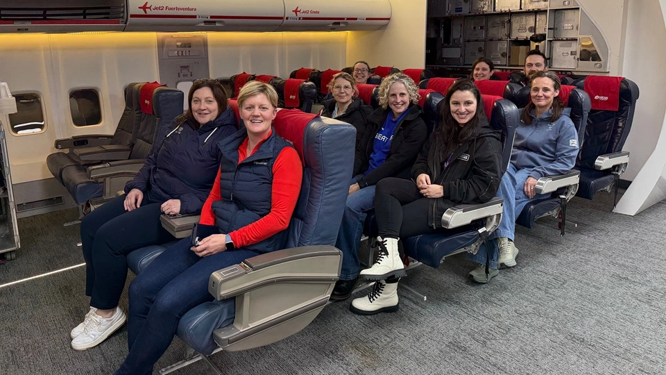 Natalia Moura with staff members from Paralympics GB sitting in an airplane simulator