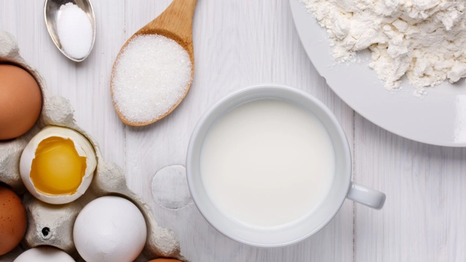 Ingredients for making pancakes. Flour, eggs, sugar and milk.