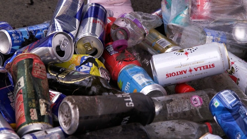 Lots of cans and litter strewn haphazardly upon the floor