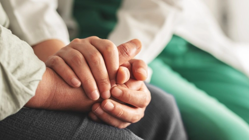 a doctor holds a patient's hand