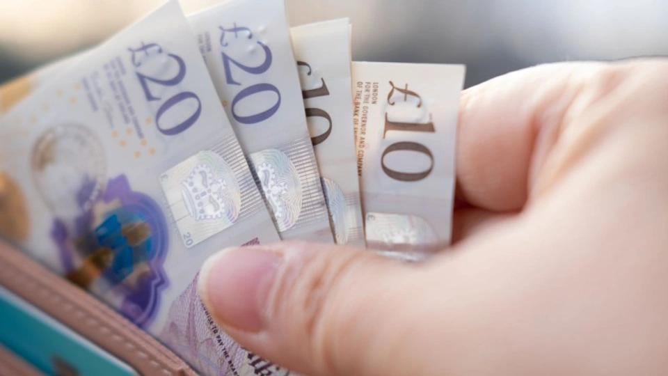 A person pulling bank notes out of a purse.