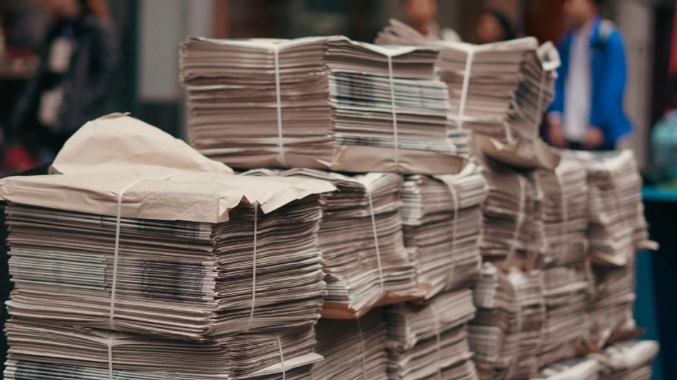 Piles of newspapers sit untouched