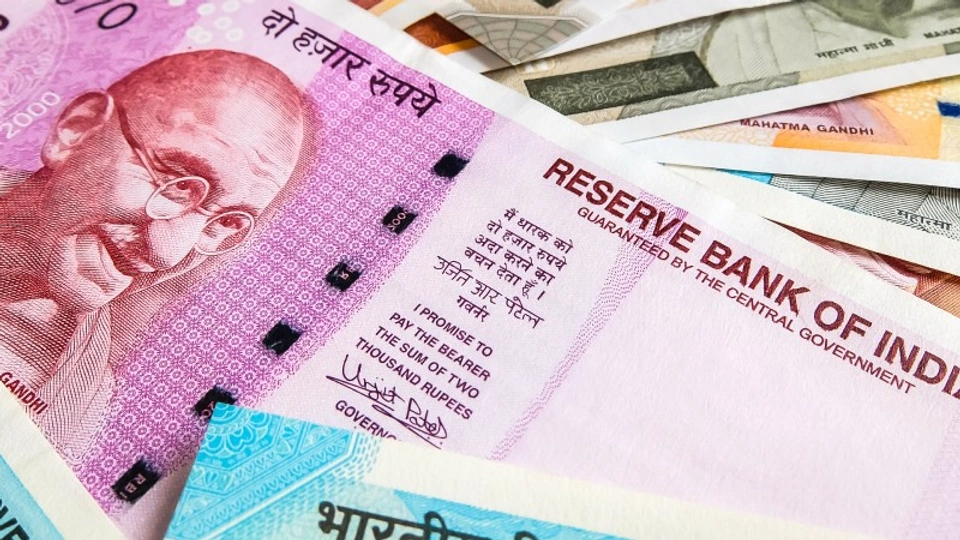 Rupee notes spread out across a table