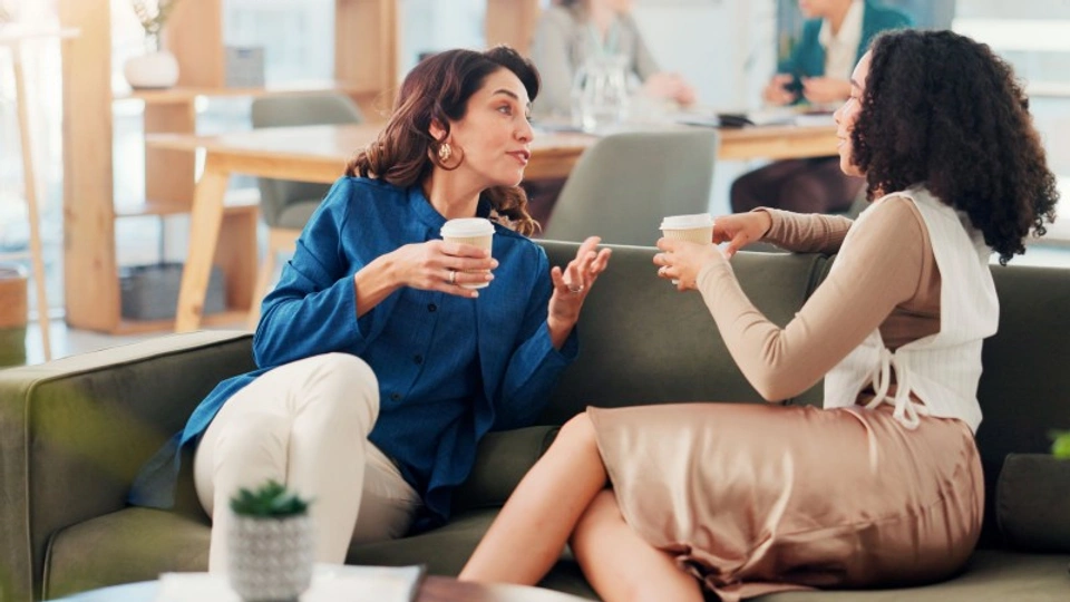 two people talking on a sofa at work