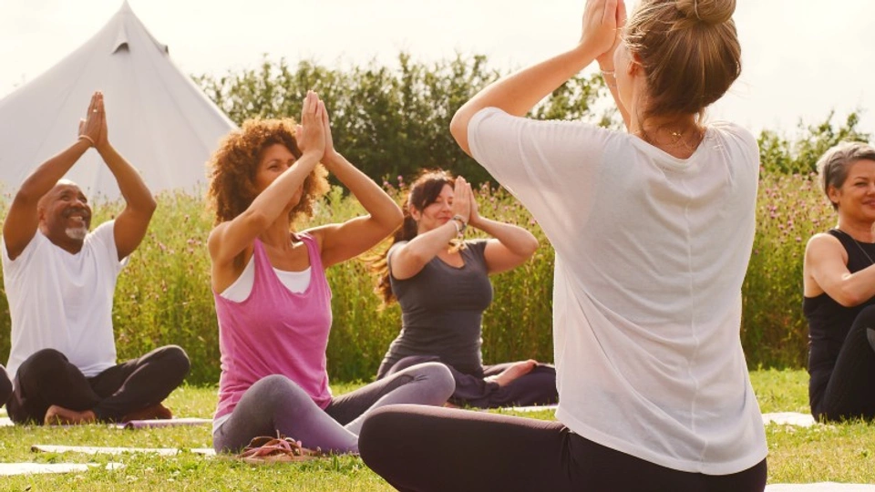 People at an outdoors yoga retreat
